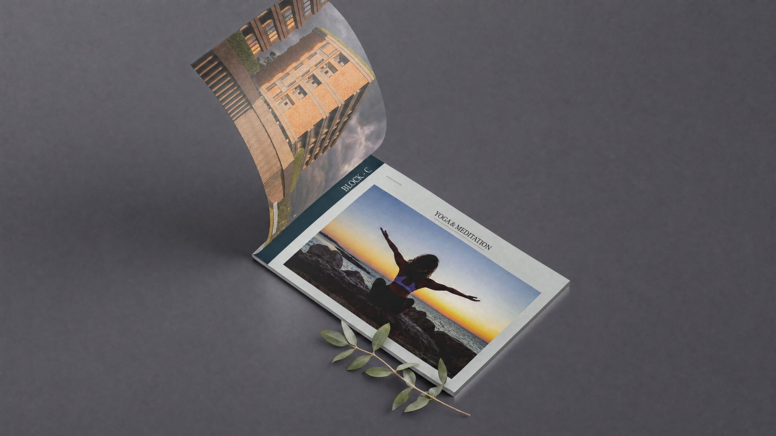 Ayati Lakeview: Brochure design mockup with a curled page showing the apartment building and a "Yoga & Meditation" page with a silhouette at sunset, with olive leaves on grey
