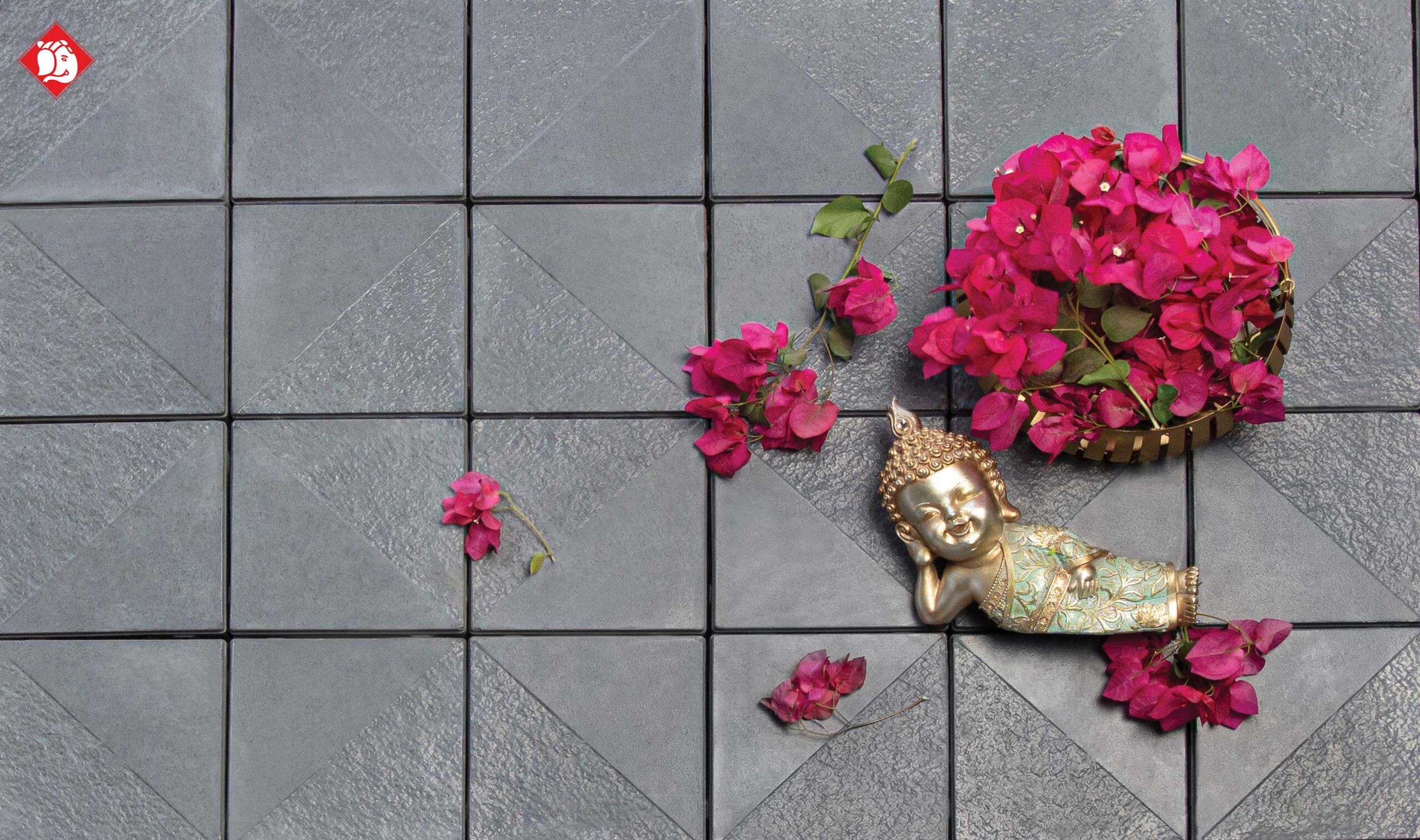 Vinayak Sanitarywares & Tiles: Grey textured tiles with a small golden Buddha statue and a basket of pink flowers