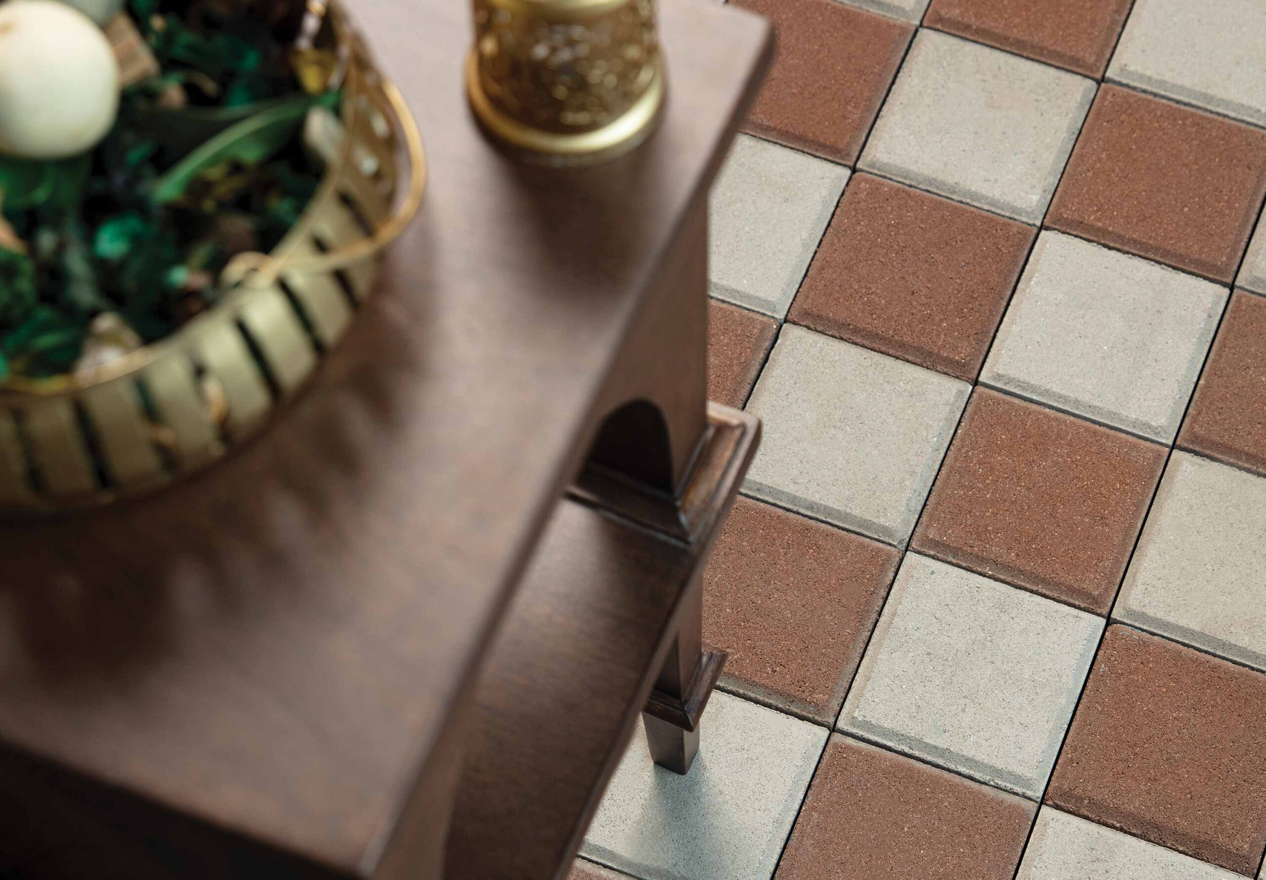 Vinayak Sanitarywares & Tiles: Brown and grey square tiles in a checkerboard pattern beside a wooden stool and a plant pot