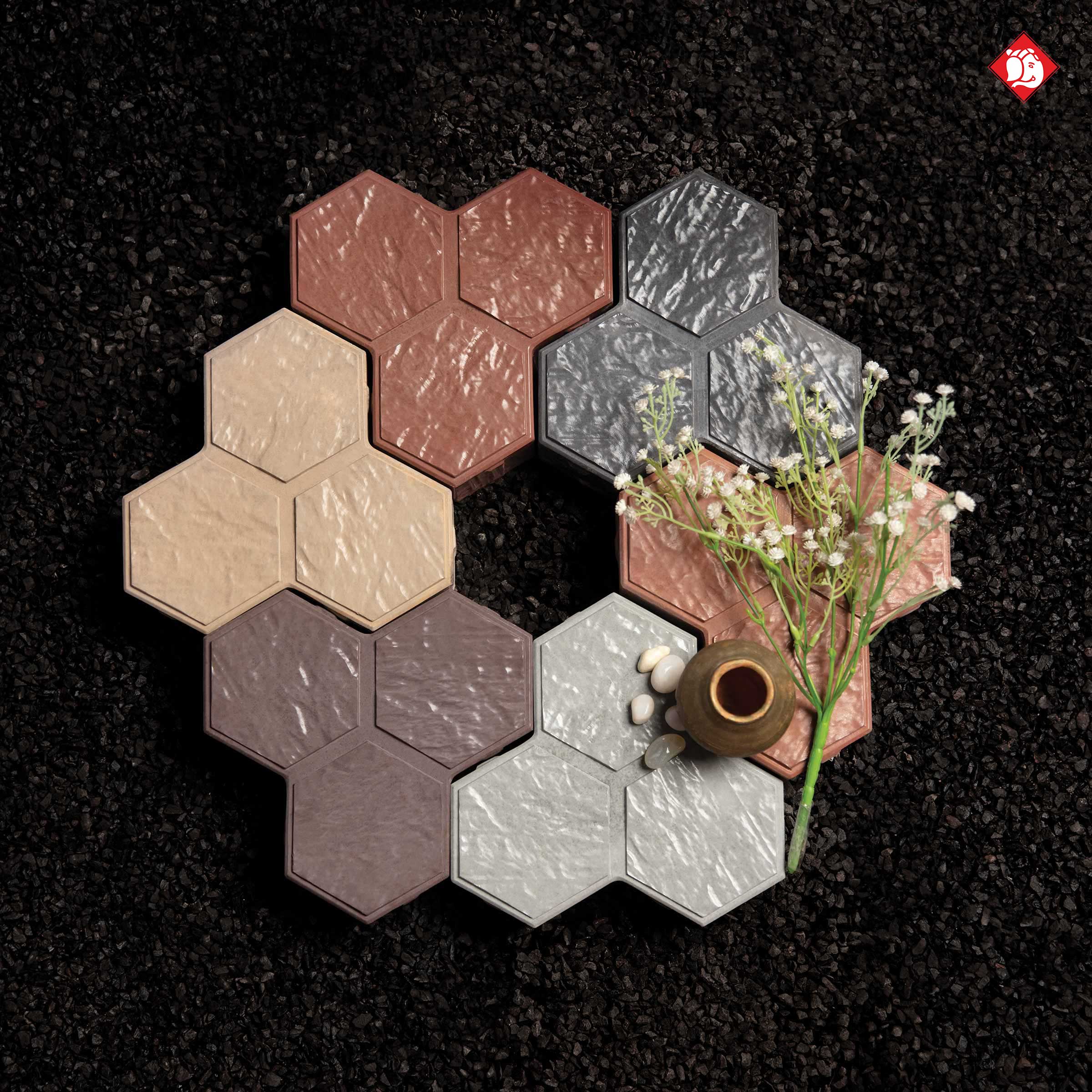 Vinayak Sanitarywares & Tiles: Hexagon tiles in brown, grey, beige and pink on a dark gravel background with white flowers
